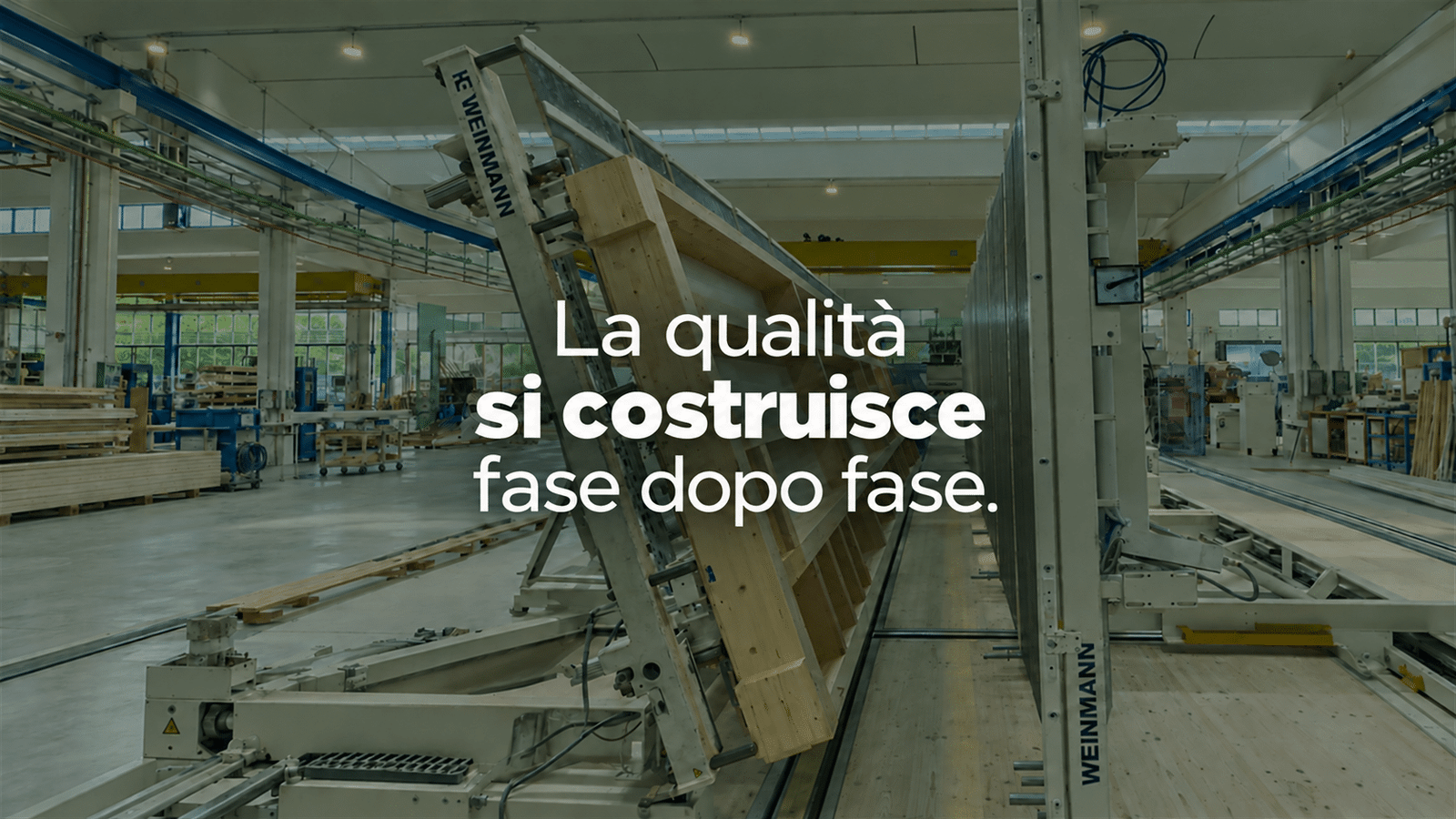 Componente in legno in lavorazione nello stabilimento produttivo, con la scritta «La qualità si costruisce fase dopo fase»